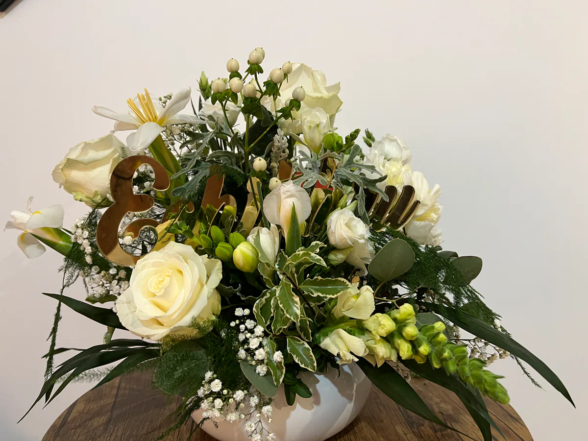 Aranjament floral alb pentru aniversare, cu cifra 18 aurie printre trandafiri și frezii