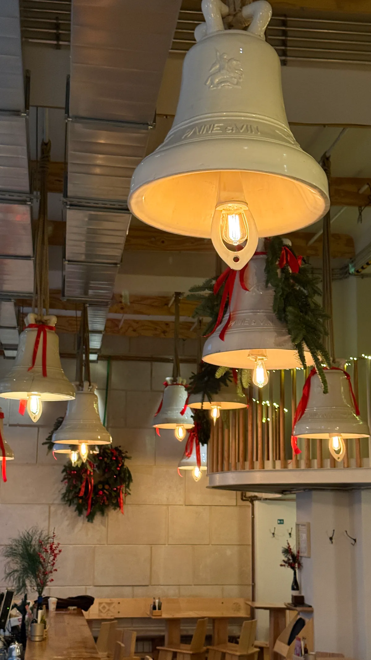 Spațiu comercial decorat de Crăciun, cu ghirlande de cetină pe corpurile de iluminat